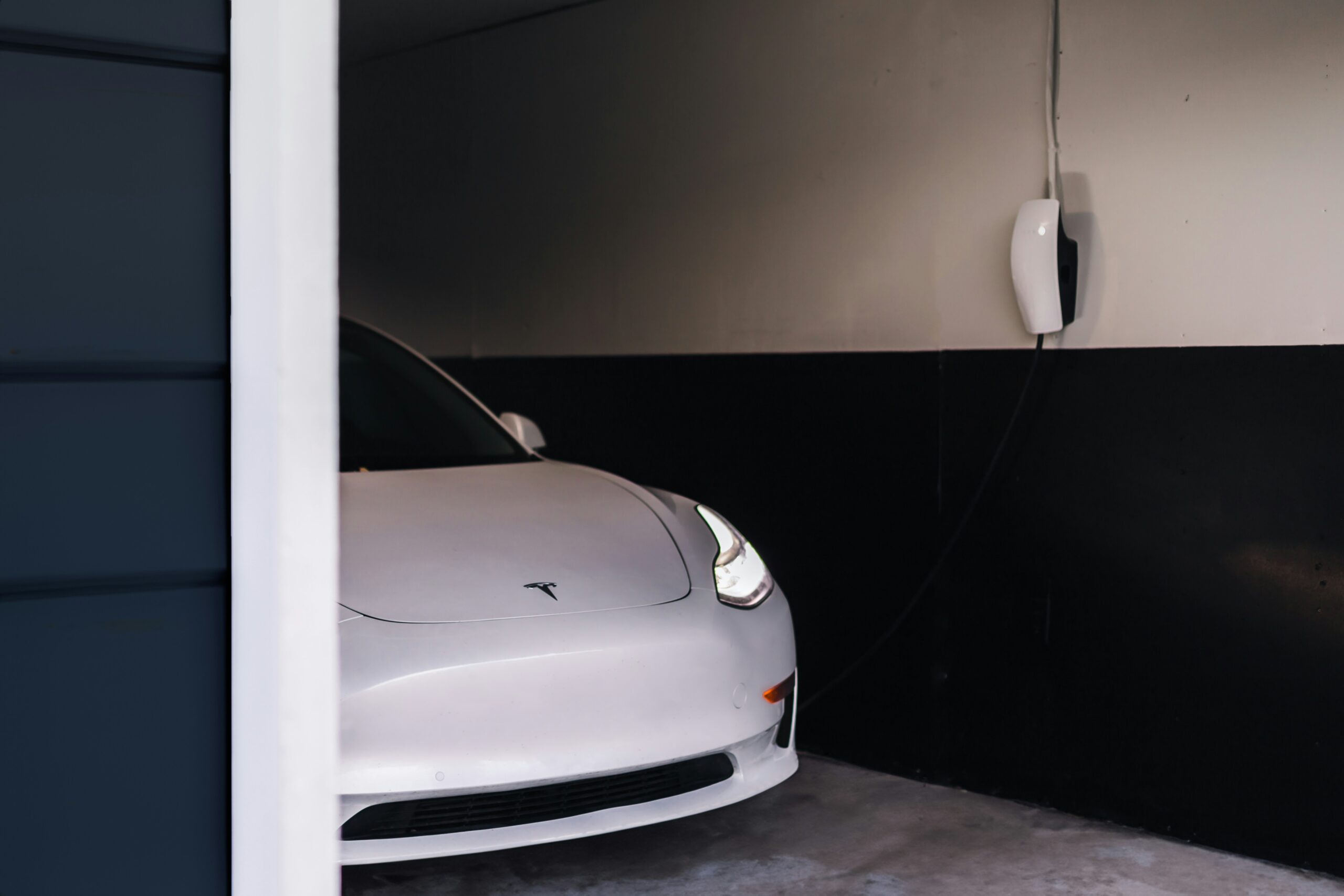 tesla charger installation in sarnia ontario white on wall with white tesla in garage.